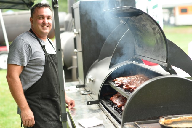 The chief cook from the QIS Team, winner of the People's Choice Award, attends to his smoker. 