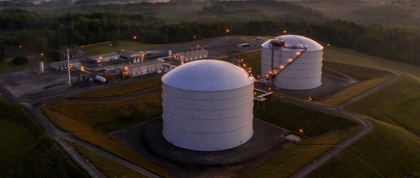 Liquid natural gas storage tanks at sunrise.