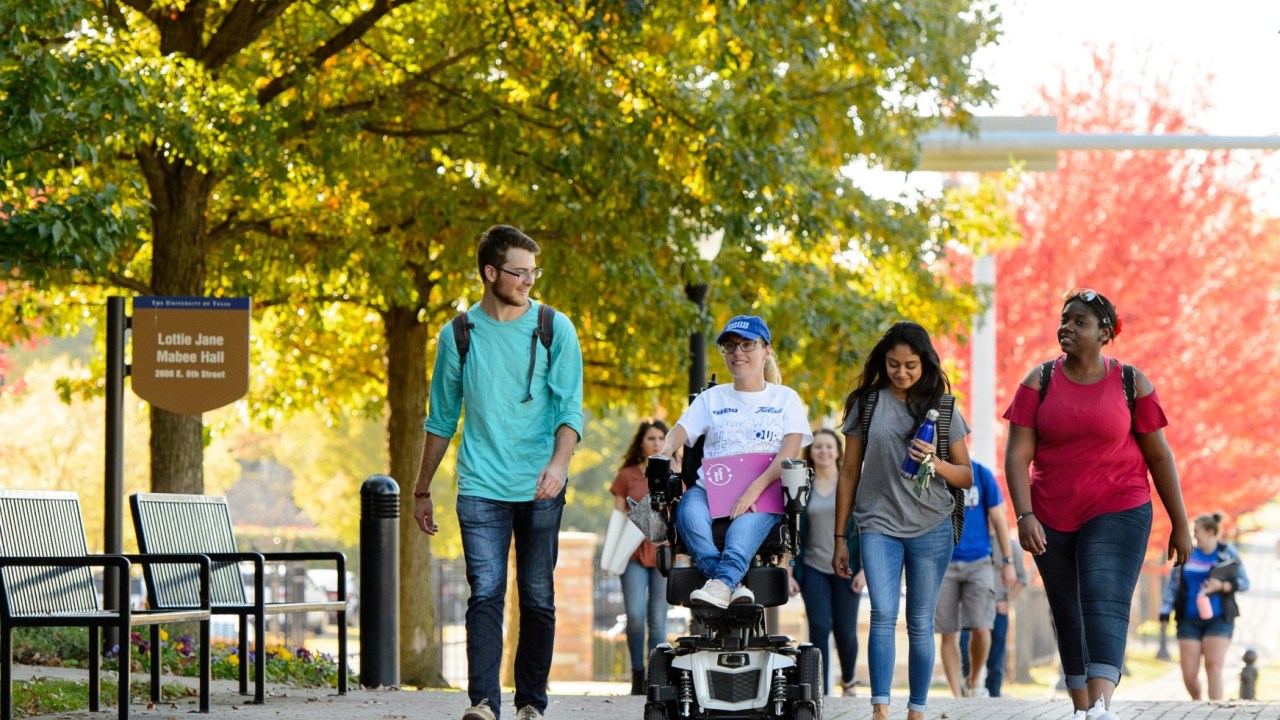 students on TU campus with fall leaves in background